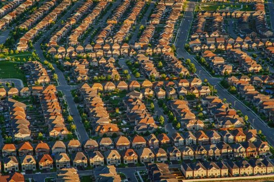 Aerial view of a suburban neighborhood with rows of houses at sunset.