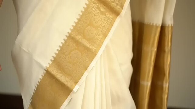 Close up of a traditional Indian Kasavu saree with gold border.