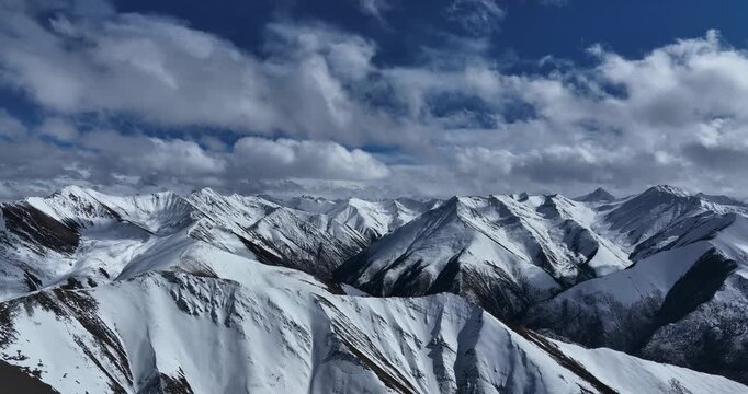Aerial footage of high altitude snow mountains and forest in tibet, China