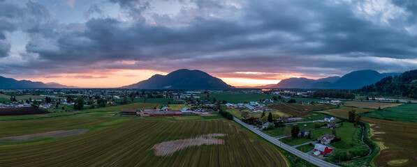 Fototapeta premium Sunset Panorama Over Fraser Valley Farmland With Mountains in British Columbia, Canada