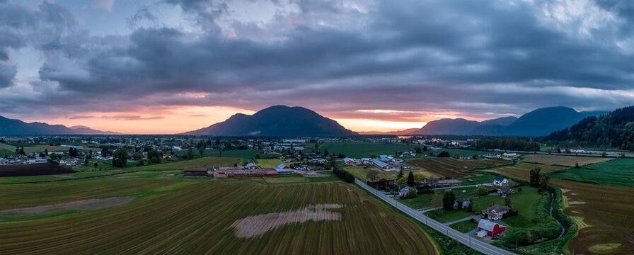 Sunset Panorama Over Fraser Valley Farmland With Mountains in British Columbia, Canada