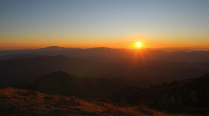 Obraz premium Sunset mountain sunrise horizon glowing sky warm light golden rays
