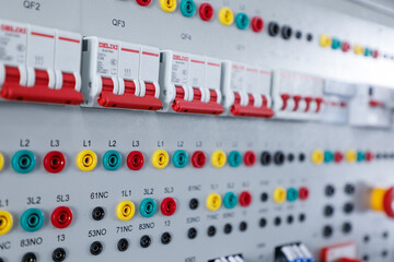Fototapeta premium Close Up of Electrical Control Panel with Circuit Breakers and Colored Terminals