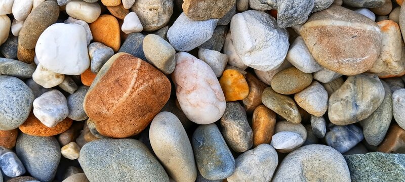 Ground shot of mixed gravel filling a gabion retaining wall. Innovative landscaping and civil engineering solution using natural stone for structural support.