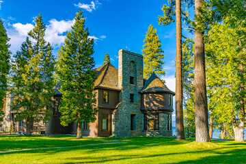 A Victorian-era stone and shingle mansion with turret and tall chimney stands amid towering pines on lush green lawn at the Tallac Historic Site, Lake Tahoe, California © ZL Visuals