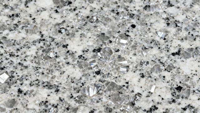 A close-up of polished granite showing speckled gray, white, and black mineral patterns.  