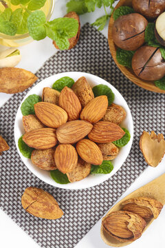 Fresh Shelled Almonds and Mixed Nuts in Bowl with Mint Leaves - Healthy Snack Food Concept