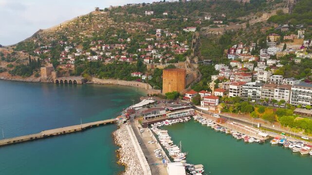 Alanya, Turkey. Kizilkule Red Tower, an octagonal Seljuk fortress of stone and brick rising above the harbor, aerial drone view on a bright summer morning. Aerial View