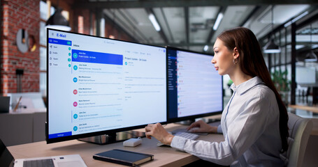 Fototapeta na wymiar Confident Businesswoman Reviews Client Emails On Desktop
