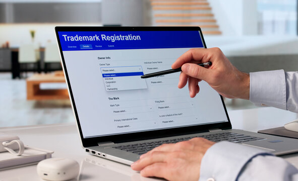 Man Working On Laptop To Register Brand