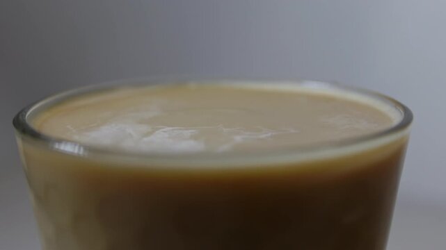 Milk drop to coffee cup and splashing up. Slow motion beverage background