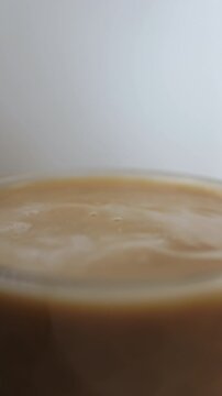 Milk drop to coffee cup and splashing up. Slow motion beverage background