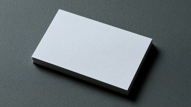 Stack of white business cards on dark grey textured surface