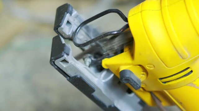Extreme close-up of electric jigsaw operating at maximum speed with fast moving blade, powerful woodworking equipment for construction, repair and industrial cutting tasks.