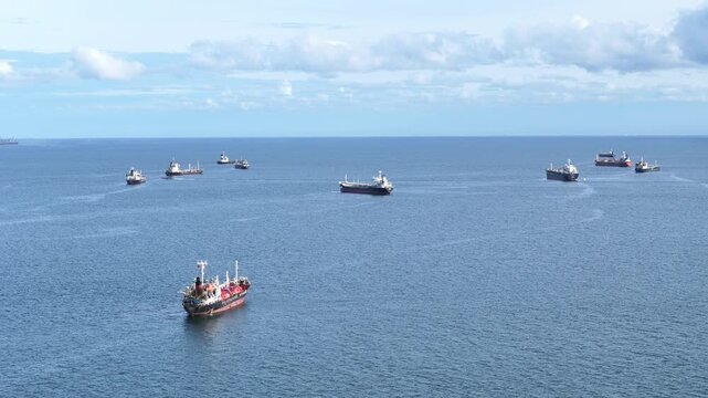 fast patrol boat with LPG gas and oil tanker ships anchored in the ocean, with a fast patrol boat in the foreground. Global energy transport, war energy crisis, and Strait of Hormuz blockade concept.