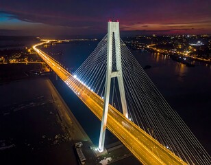 Fototapeta premium Cable-stayed bridge over water at night.