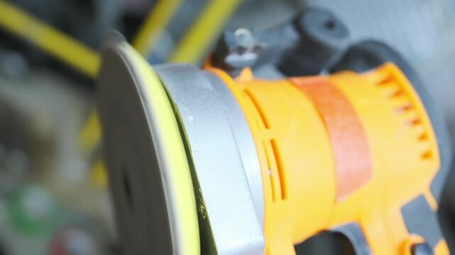 Orbital sander running at maximum power in close-up, professional electric polishing machine for renovation, woodworking, finishing and industrial repair work.
