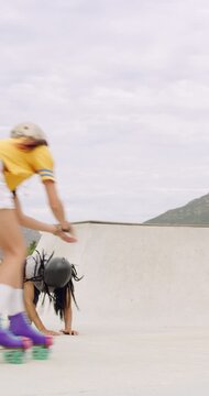 People, rollerskater and fall in urban skate park for outdoor hobby, accident or playful incident. Man, woman or partner clapping with tumble on ramp for motivation, trick or quick recovery on floor