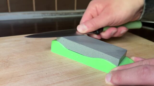 Kitchen knife sharpening on stone board close up