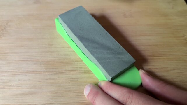 Kitchen knife sharpening on stone board close up