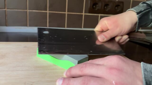 Kitchen knife sharpening on stone board close up
