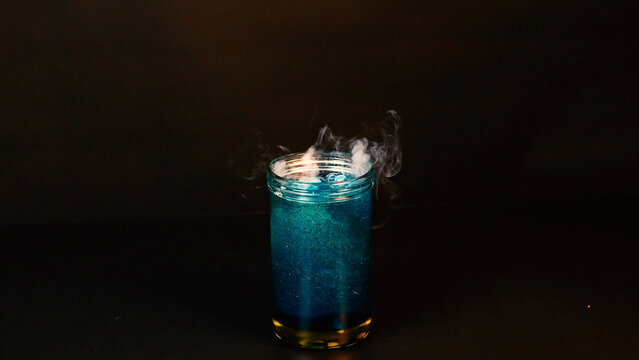 Dry Ice Sublimating in a Glass Jar of Bubbling Blue Liquid