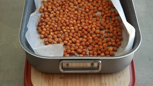 Close-up of crispy, seasoned baked chickpeas cooling on a metal baking tray right out of the oven