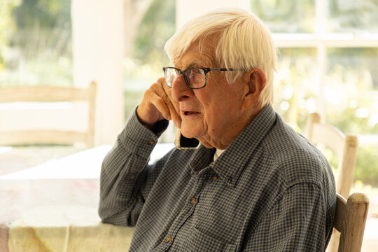 elderly man talking on cellphone at home