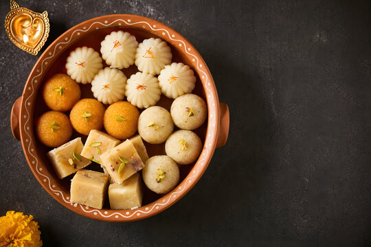 Traditional Indian sweets arranged in clay pot offering