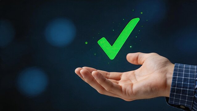 Hand holding glowing green checkmark symbolizing success, approval, verification, or positive outcome in business and digital contexts with modern tech background