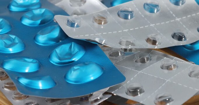 Horizontal view of multiple empty medication blister packets spinning on a rotating turntable platform for pharmaceutical research.