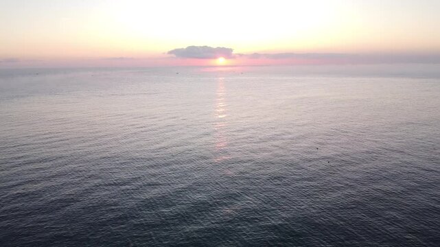Beautiful sunrise over the calm sea with sun reflection on water