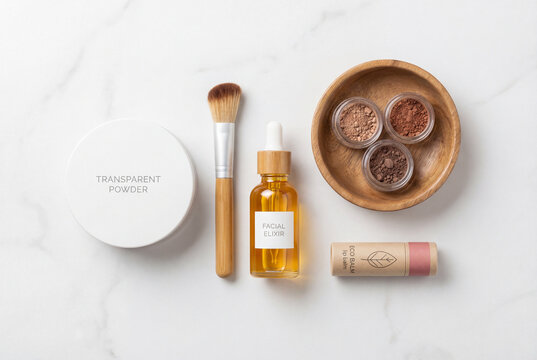 Eco friendly cosmetic items powder brush elixir eyeshadows balm flat lay