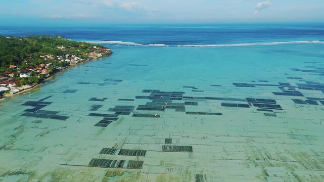 Aerial tracking shot of vibrant turquoise sea water between Nusa Lembongan and Ceningan islands &ndash; Amazing natural sand patterns and coastal landscape in Indonesia, cinematic advertising asset