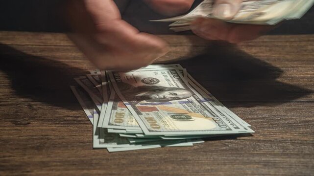 Rich man is holding USD banknotes in hands and counting money.