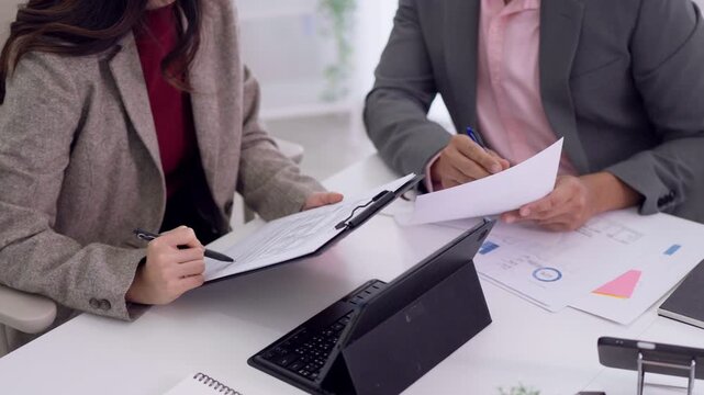Asian businesswomen professional team meeting review financial report data analysis chart document presentation collaboration office workspace teamwork