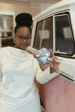 Stylish woman checks reflection in vintage van mirror