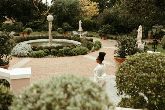 Woman standing in a beautiful formal garden courtyard