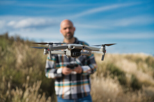 A man pilots a drone outdoors, practicing trail tracking.