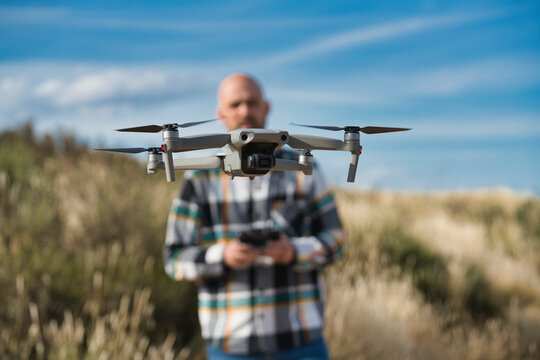 Close-up of a drone, with the pilot behind it practicing flight