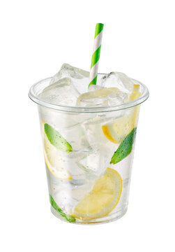 Lemonade in transparent disposable plastic cup with ice, lemon slices and fresh mint leaves isolated on white background