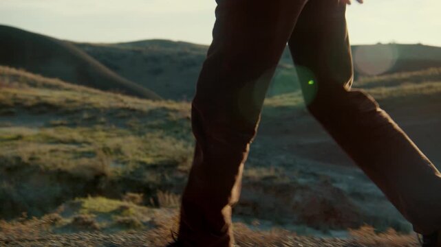 Stylish man with fantasy elf ears posing confidently in a desert landscape. Cinematic fashion aesthetic, dramatic light, and surreal atmosphere create a unique fantasy-inspired scene.