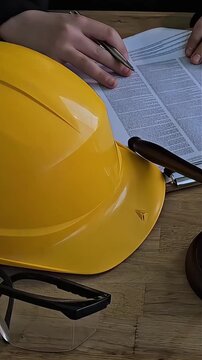 Court scene with hard hat, safety glasses, and gavel on desk during legal proceedings related