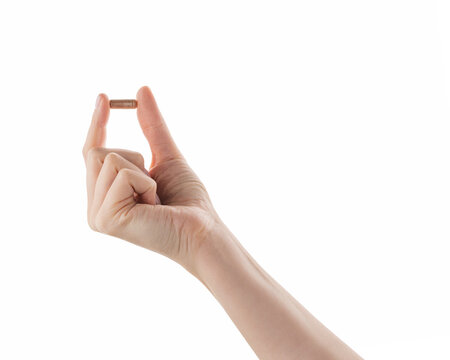 Female hand hold beige pill isolated on white