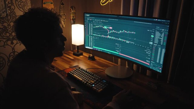Professional trader or investor working at multiple monitors with stock market charts, financial data, and trading graphs.