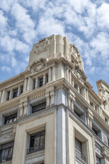 Fototapeta premium Building Facade with Ornate Stone Carvings, Barcelona, Neoclassical Pillars, Historic European Architecture