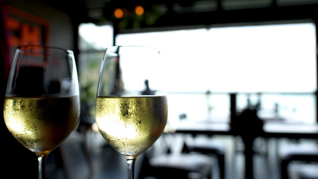 Two Chilled Glasses of White Wine with Condensation in a Restaurant