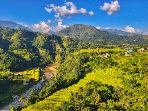 Lush green hills near Pokhara, Nepal under a clear blue sky with layered mountain landscape in the distance, capturing peaceful countryside scenery and the natural beauty of the Himalayan foothills.