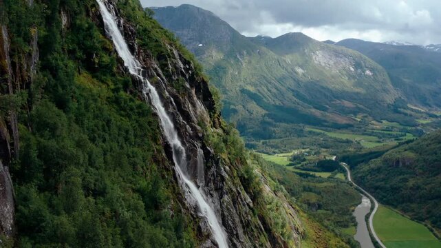 4K aerial drone zoom out footage of a majestic waterfall cascading into a wild mountain river valley in Klakegg, Norway. Scenic epic summer wilderness landscape in Scandinavia in July.