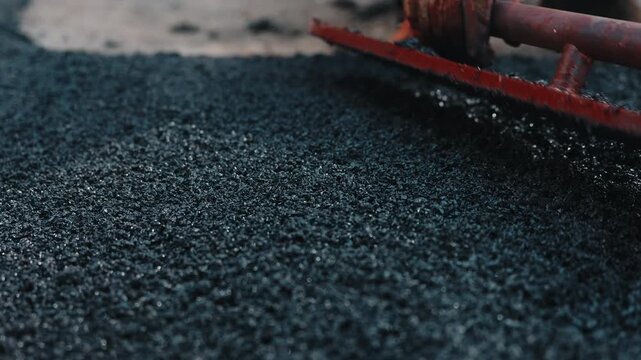 Leveling rubber crumb surface with finishing tool close up
